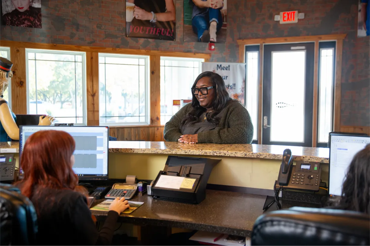 Image of someone being greeted at the front desk of the dental office